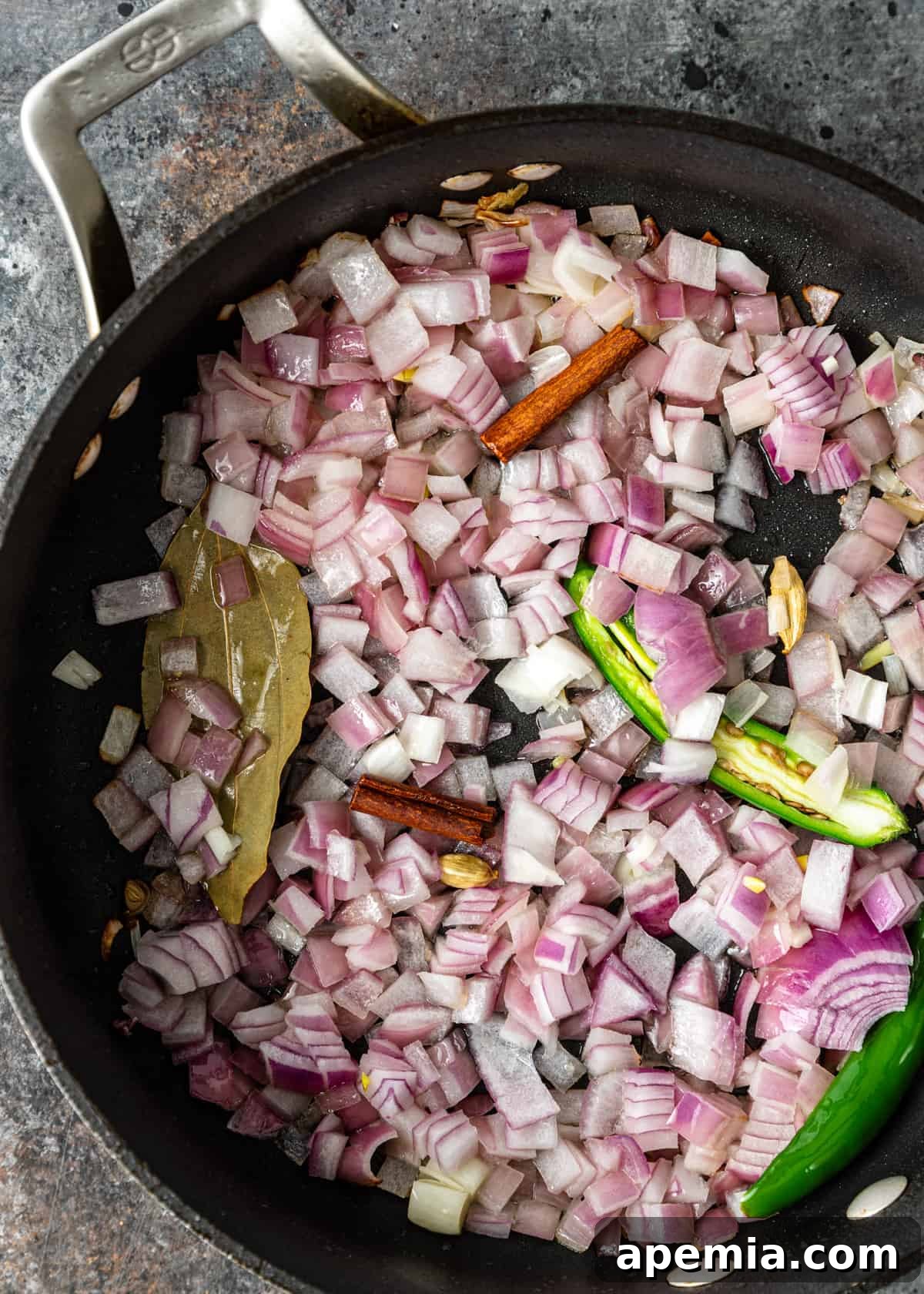 overhead process shot: titled image (and shown) saute onion, chili, spices
