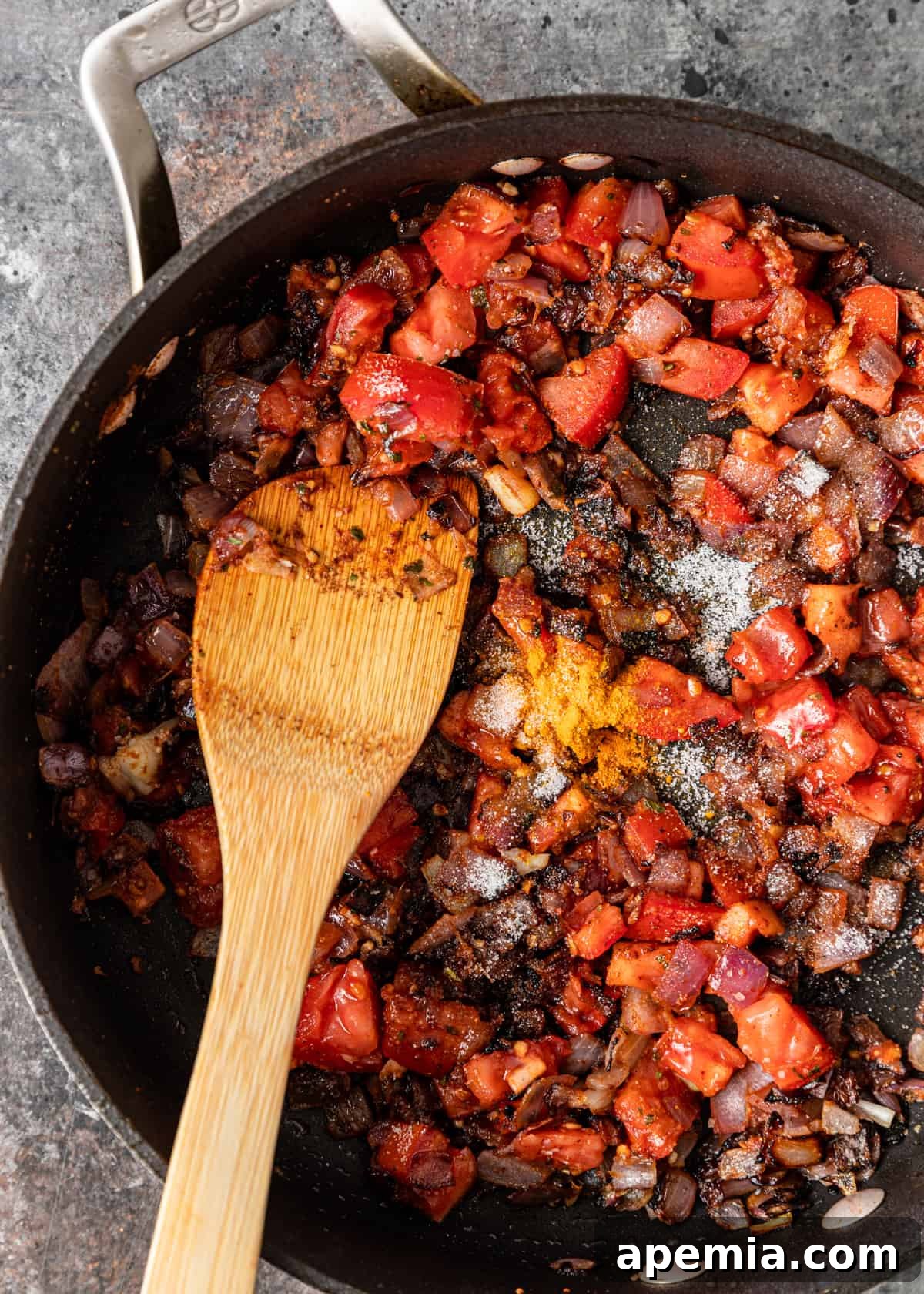 overhead process shot: titled image (and shown) add tomato, spices