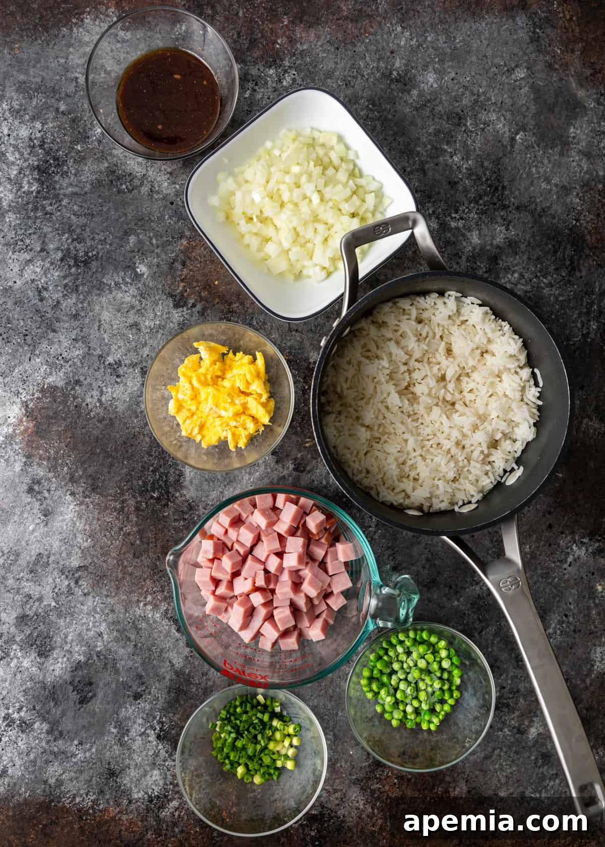 Overhead shot showing all the prepped ingredients laid out on a counter, ready to make pork fried rice.