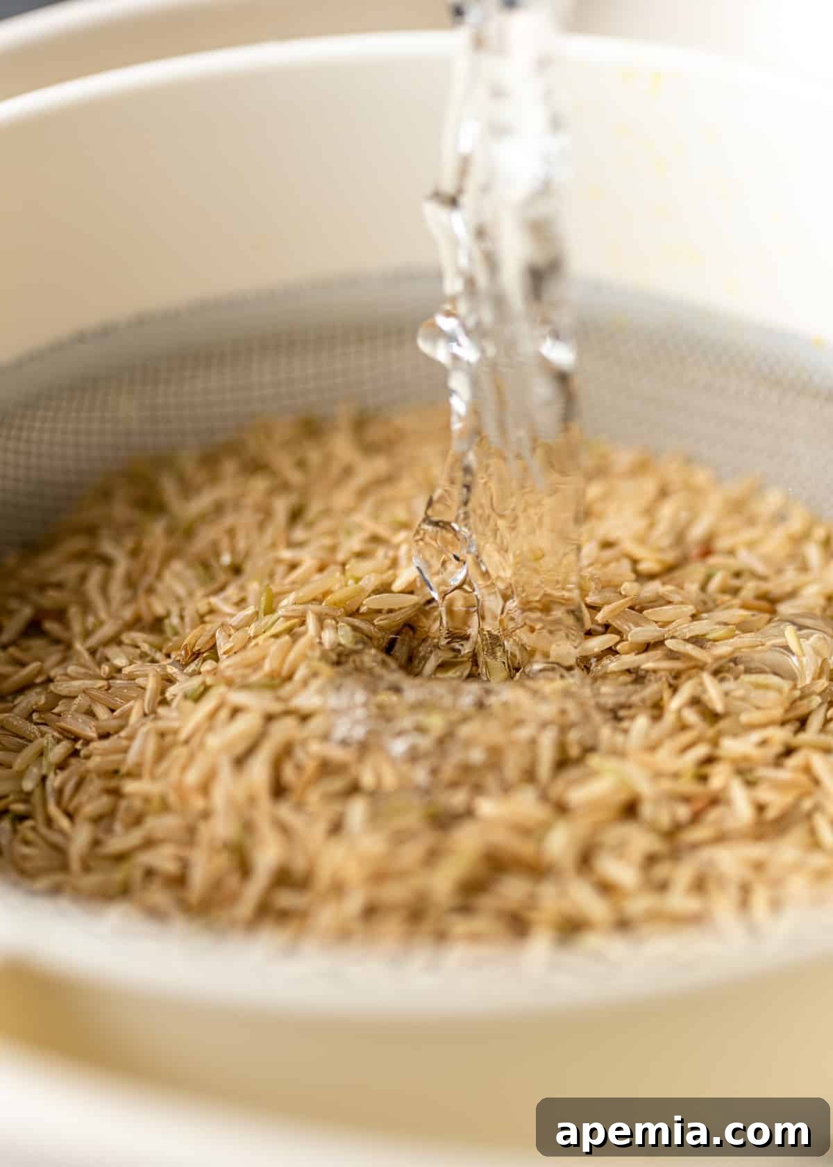 rinsing brown basmati rice in strainer under cold water