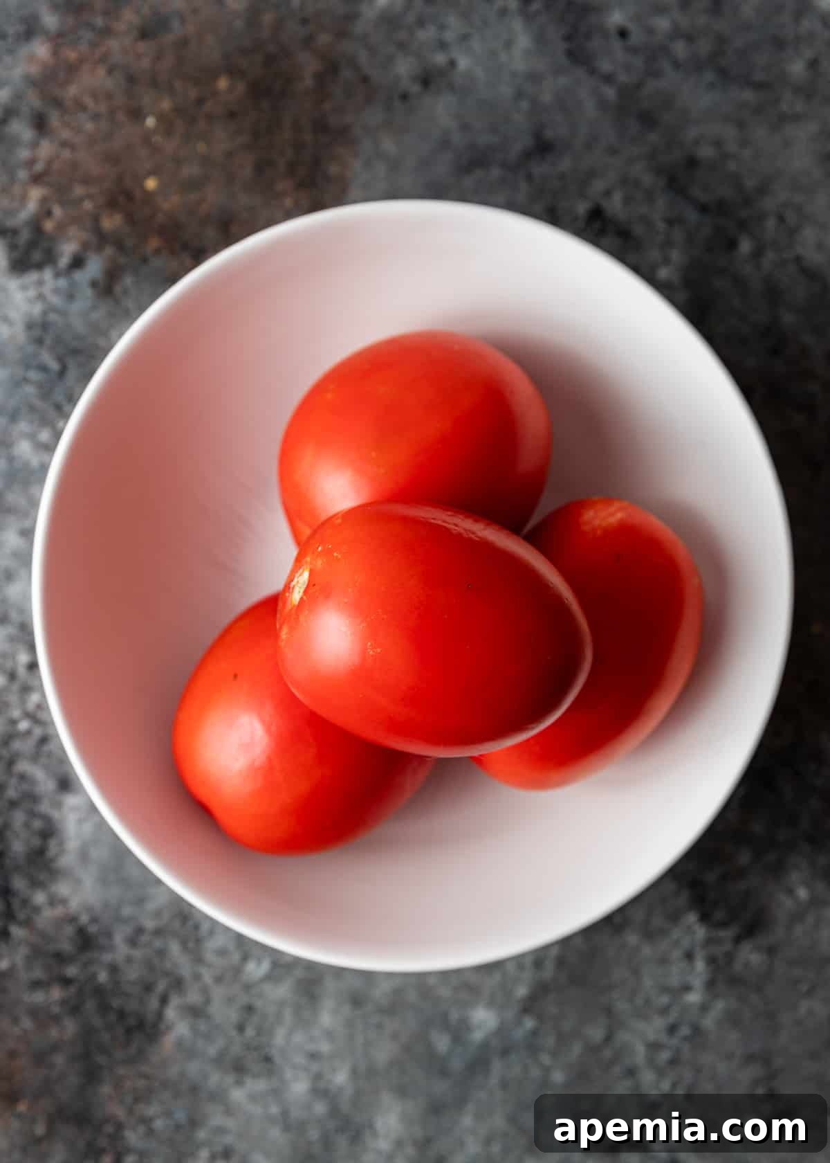 Fresh, ripe tomatoes in a bowl, ready for processing.