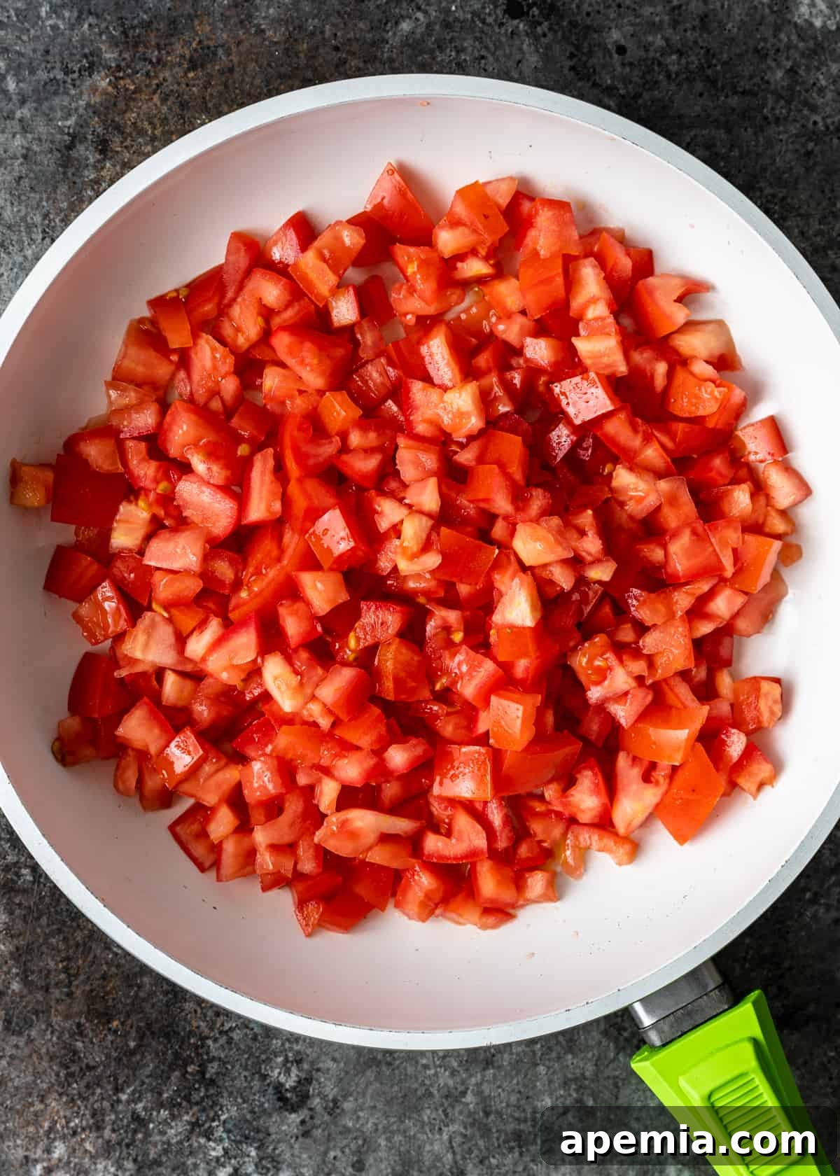 Sweet Heat Tomato Chutney 5 Overhead process shot: Diced tomatoes beginning to cook down in a skillet.