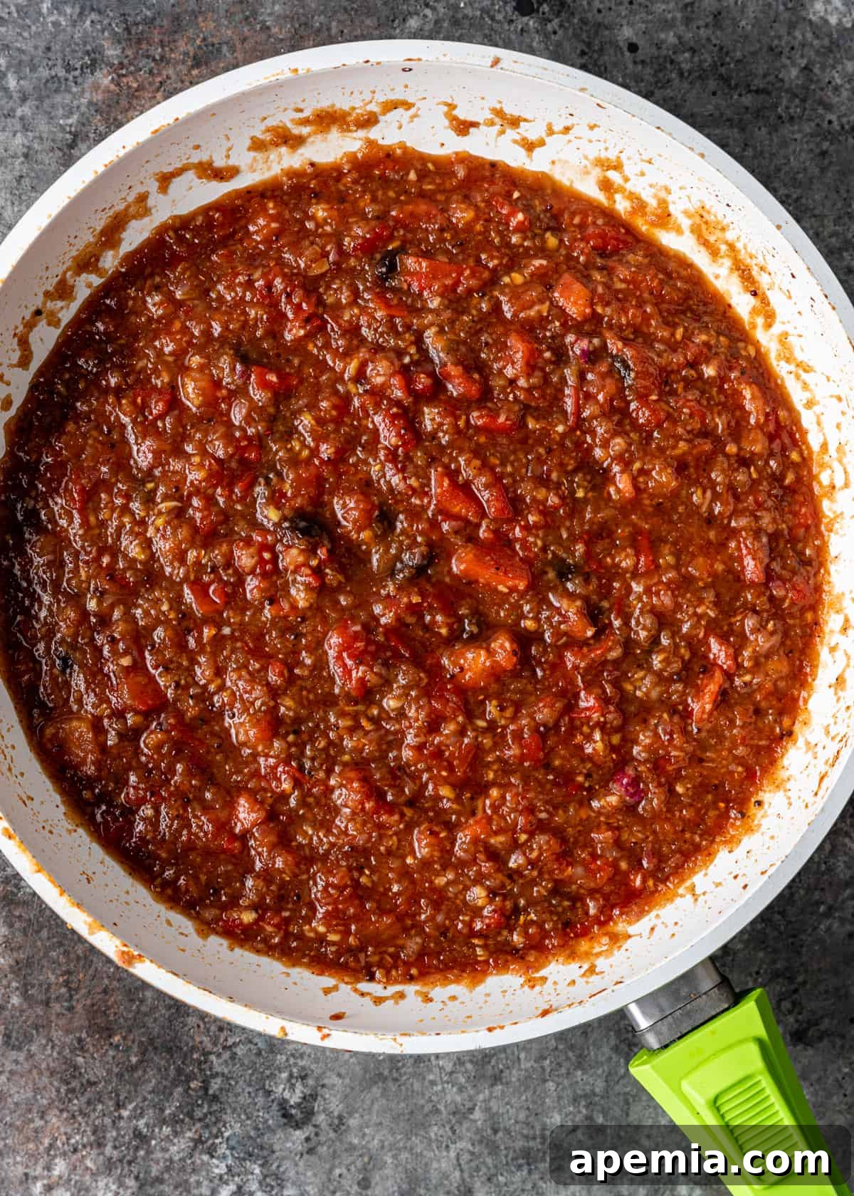Sweet Heat Tomato Chutney 9 Overhead shot of the sweet and spicy tomato chutney simmering and cooking down in a skillet, nearing completion.