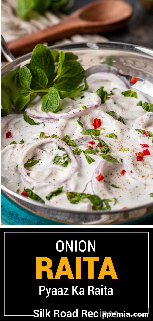 A large bowl of Onion Raita, garnished with a generous amount of fresh mint and a sprinkle of spices, presented artfully.