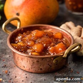 A top-down shot of a small jar filled with homemade mango chutney, sealed and ready for storage or gifting.