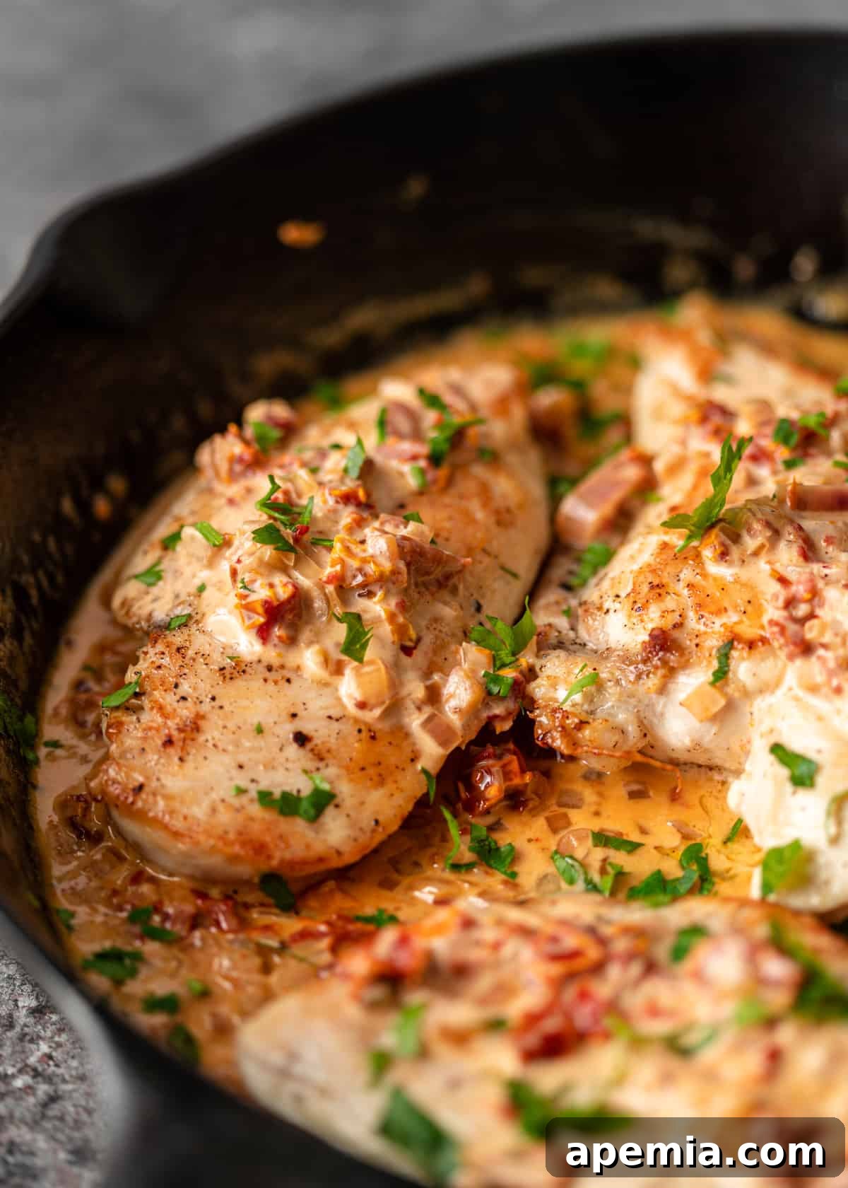 Closeup of Creamy Tuscan Chicken in a skillet, showcasing the rich sauce and tender chicken