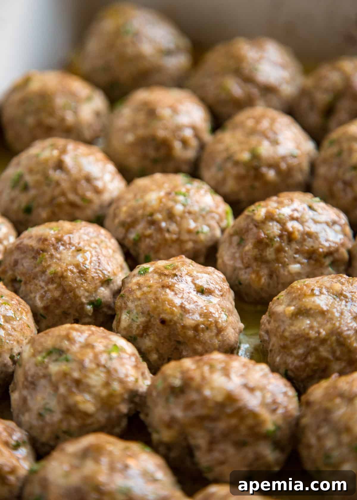 Close-up of roasted Italian meatballs in a baking dish, perfectly browned and ready to be sauced.