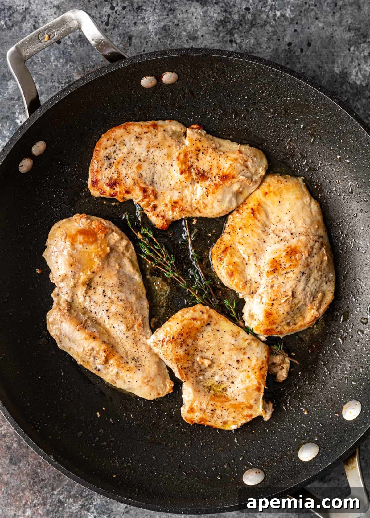 Rich and Creamy Marsala Chicken 5 chicken cooking in a skillet