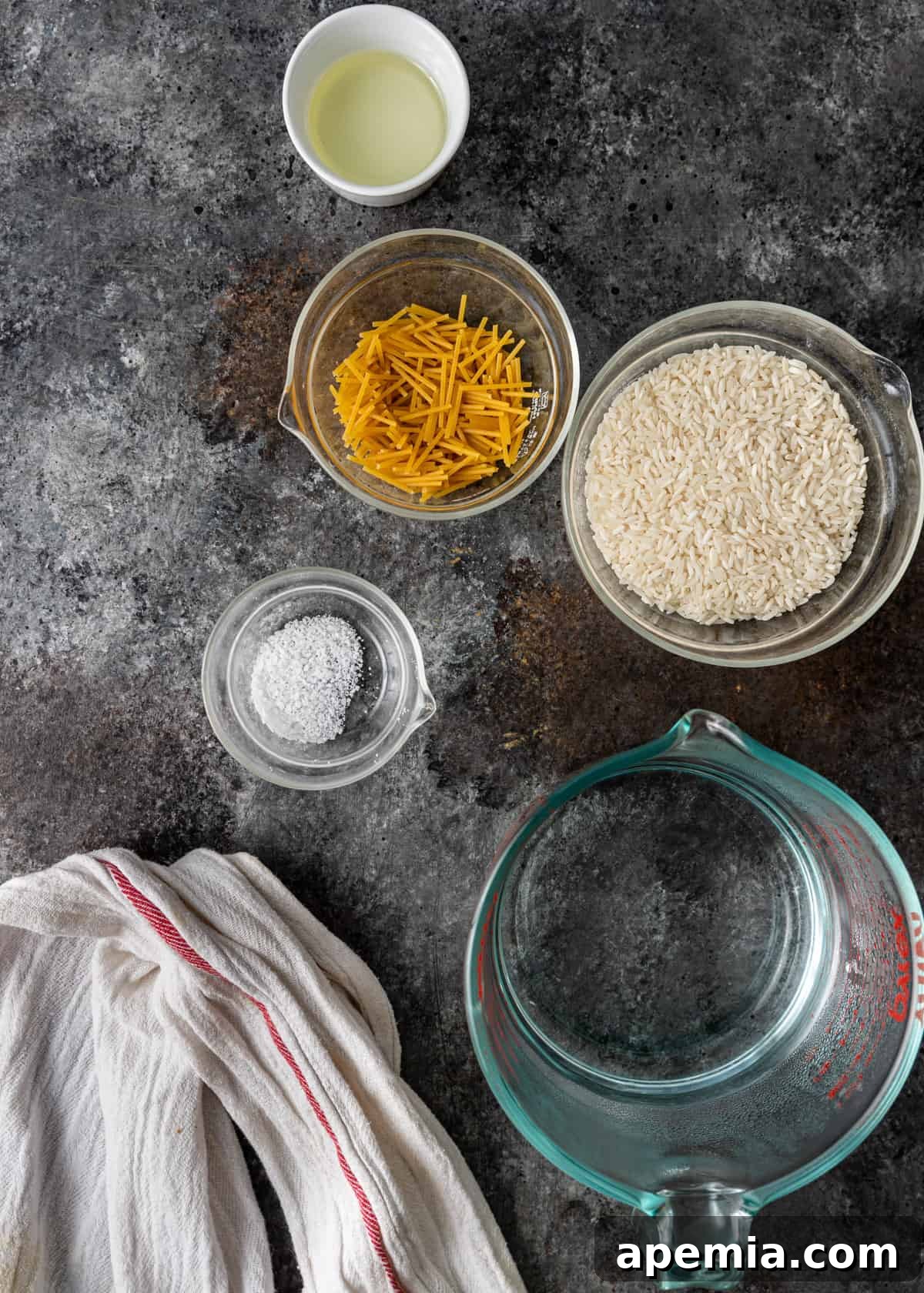 Ingredients laid out for preparing Egyptian rice with vermicelli, including oil, rice, and pasta.
