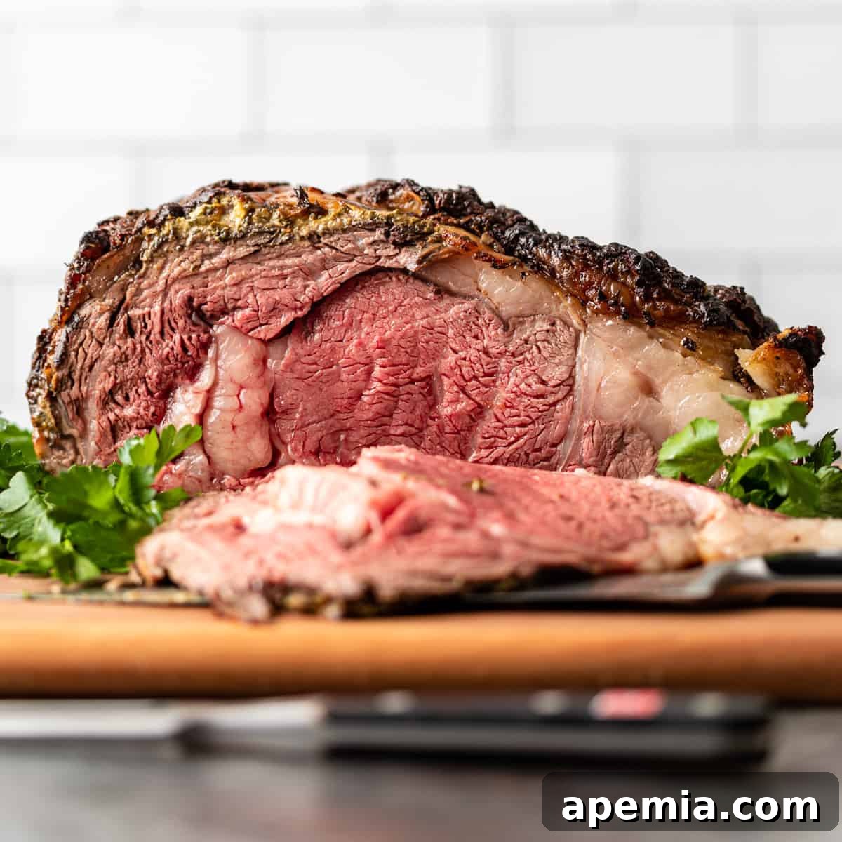 side view closeup: prime rib roast over fresh herbs with a slice taken out