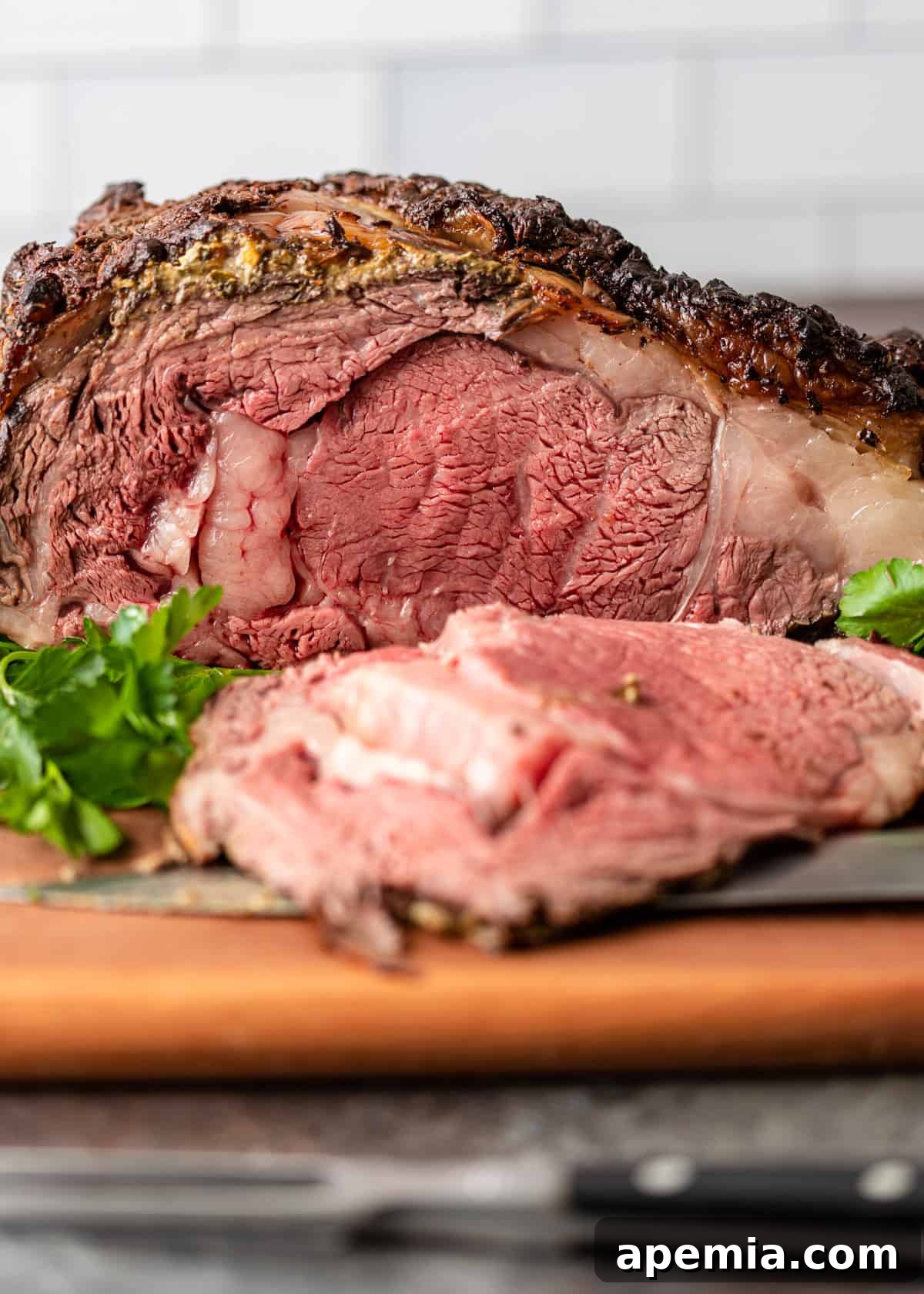 side view closeup: roast standing rib roast with a slice taken out so the center is visible