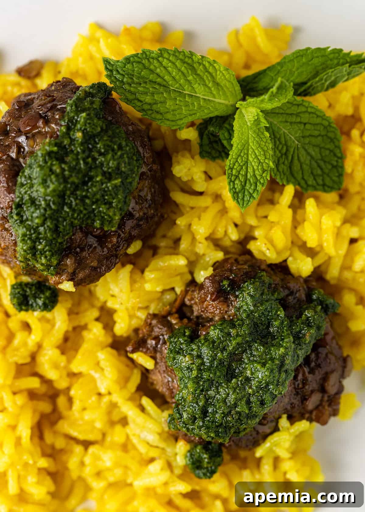 Mediterranean Lamb Lentil Meatballs and Zesty Lemon Rice 3 Extreme close-up showcasing the rich texture of lentil lamb meatballs, glistening lemon rice, and a vibrant swirl of mint pesto.