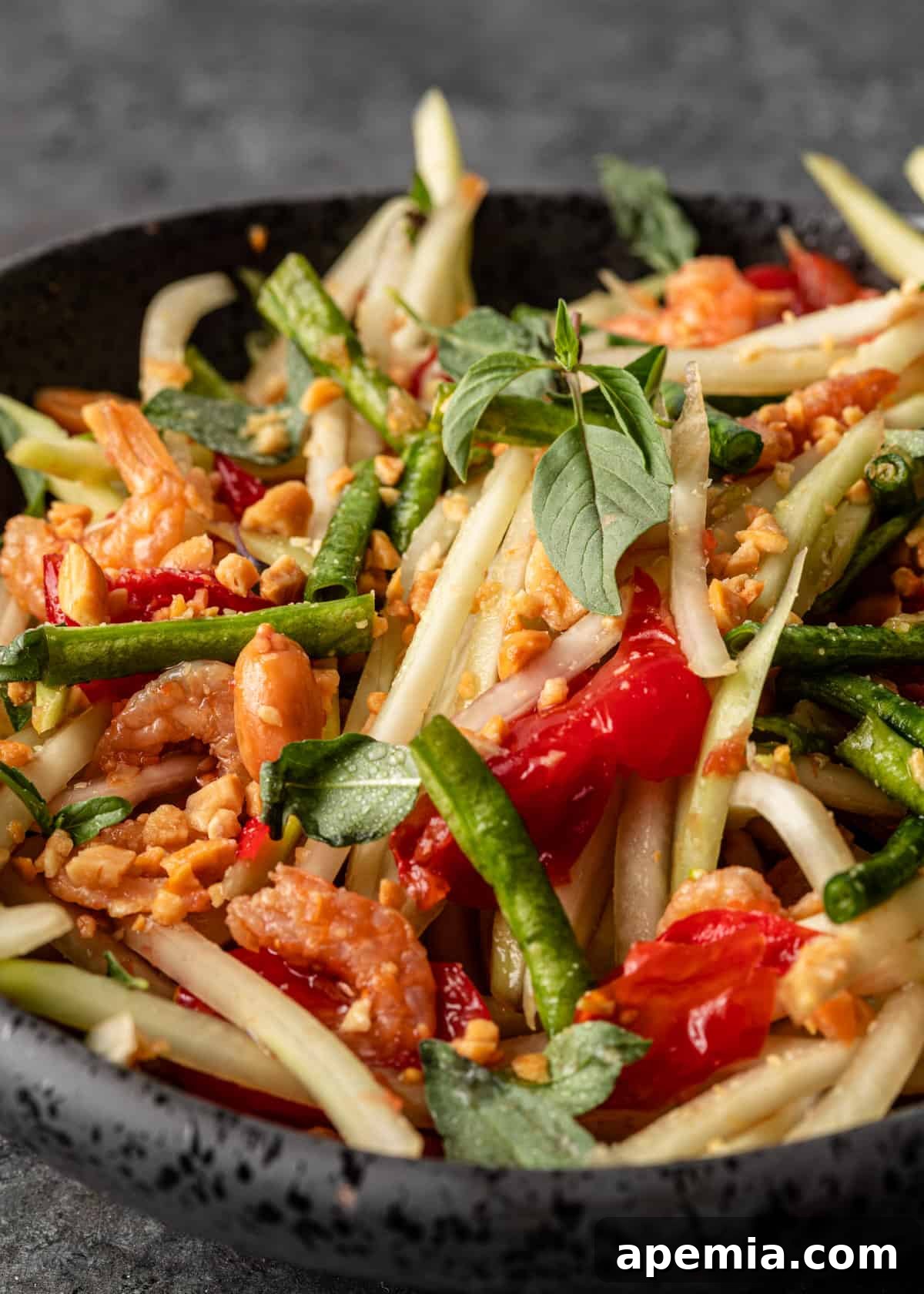 extreme closeup: som tum salad with lots of vegetables and peanut sauce