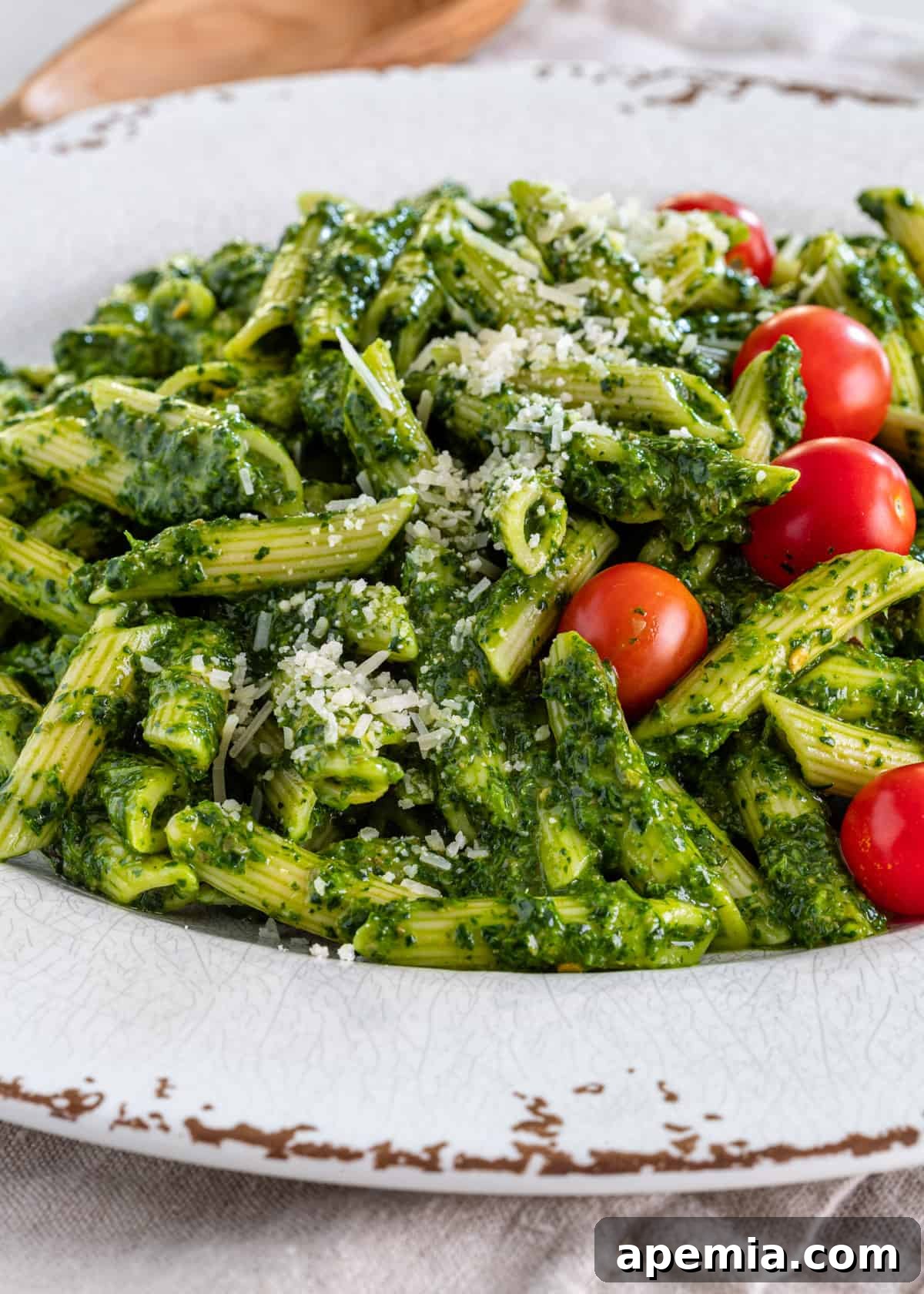 Vibrant Italian Green Sauce 6 closeup side view: penne and sauce verde with Parmesan and cherry tomatoes on top