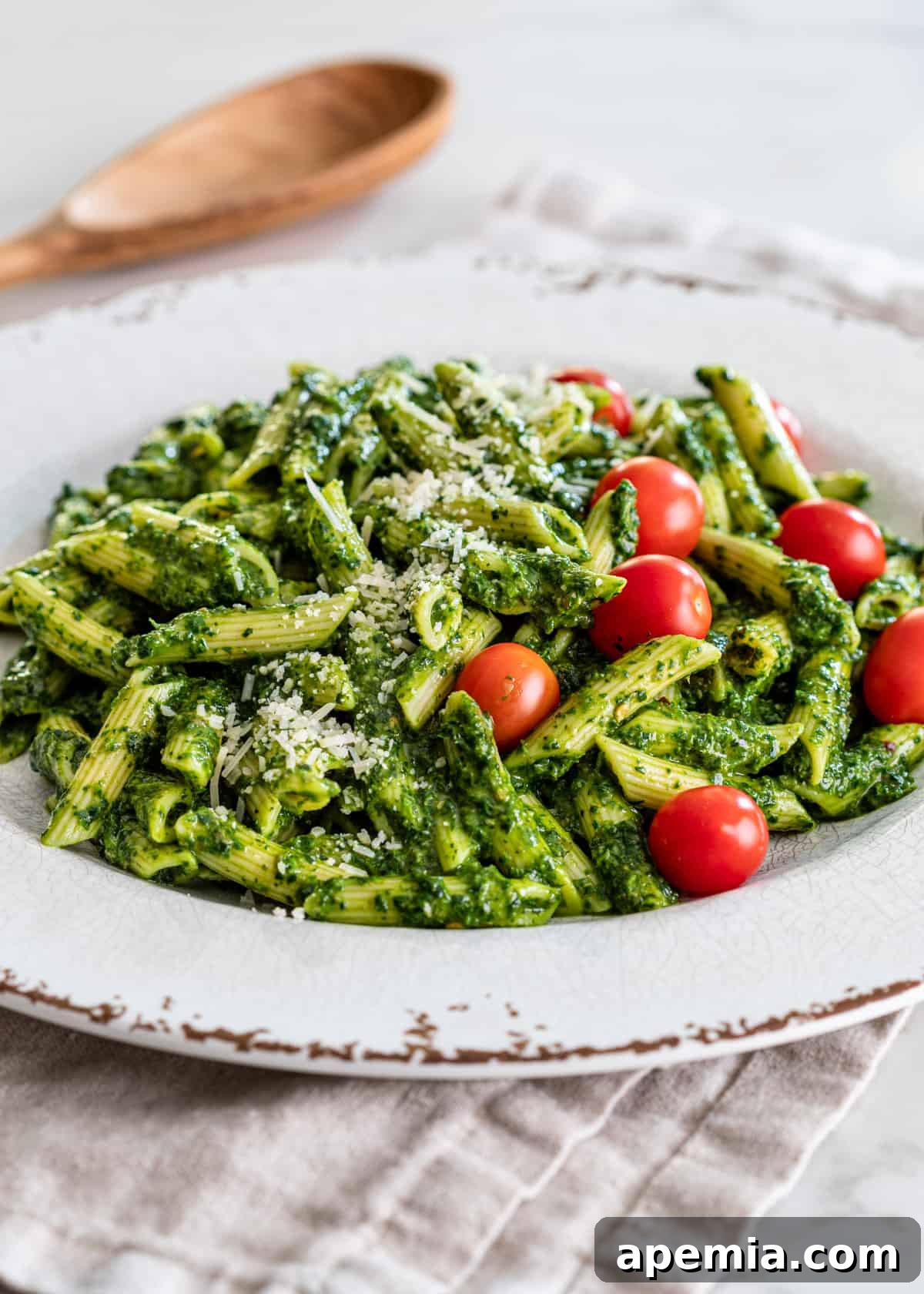 Vibrant Italian Green Sauce 7 side view: a serving of penne with my italian salsa verde recipe, cherry tomatoes, and parmesan cheese on top