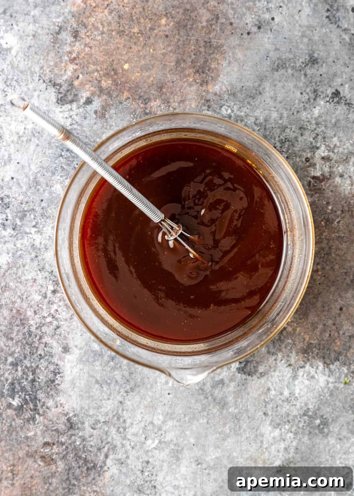 overhead: a small whisk in a bowl of katsu sauce