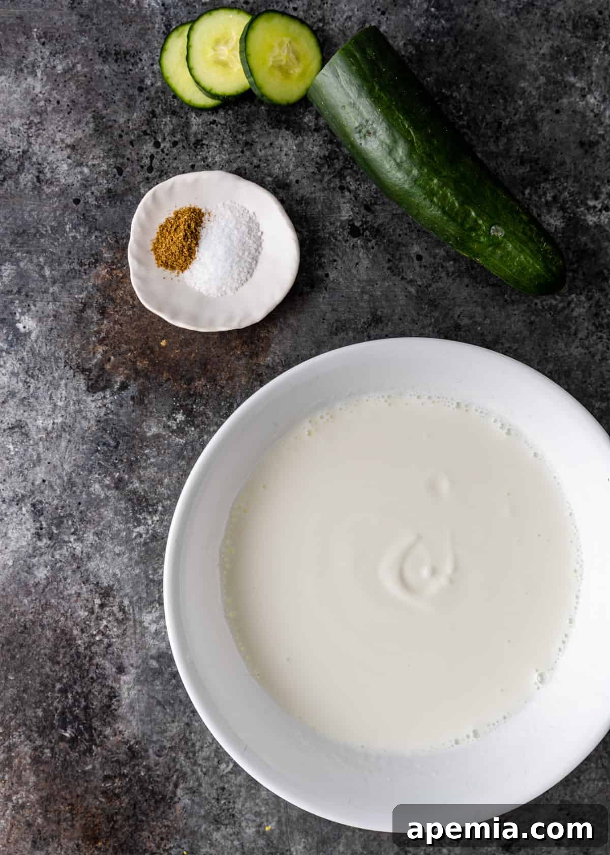 overhead: ingredients needed for this cucumber raita recipe, laid out on a clean surface