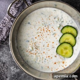 Cucumber Raita in a small bowl, garnished with cucumber slices and a sprinkle of spices
