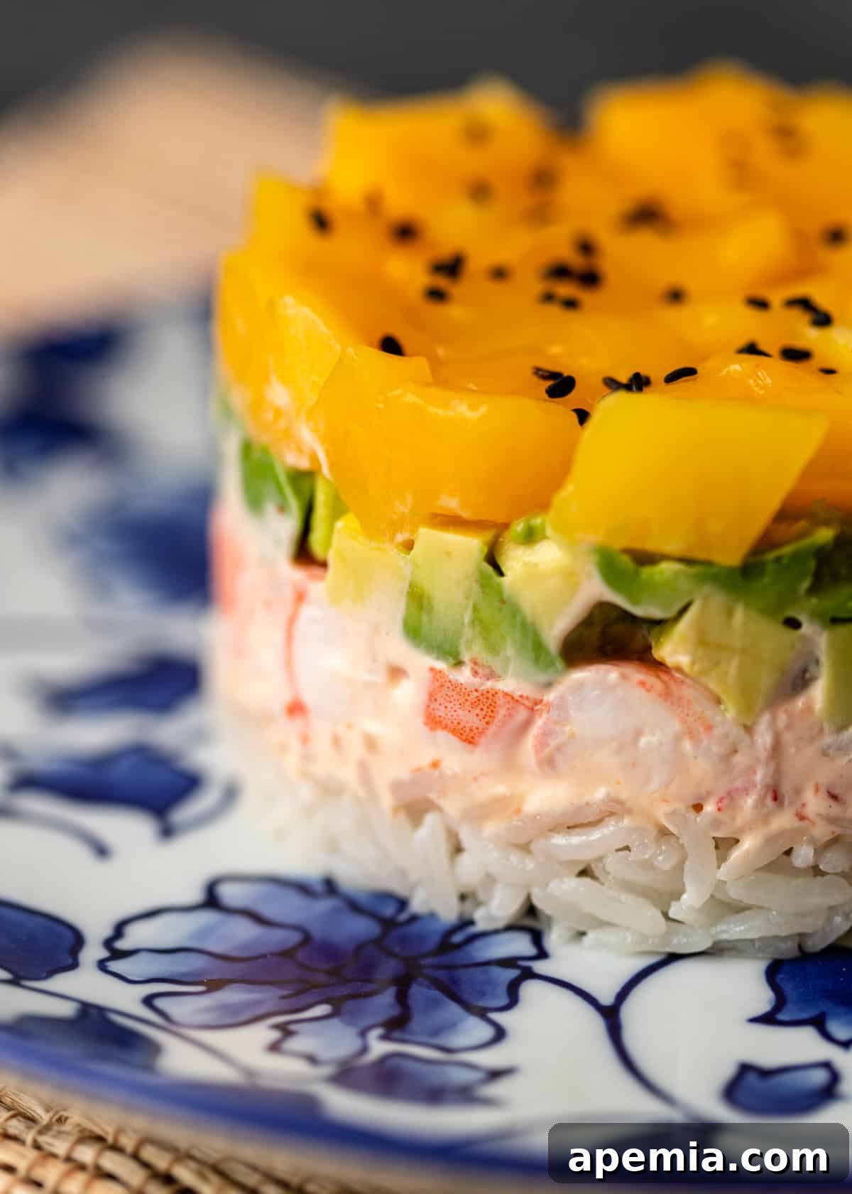Extreme close-up of a mango shrimp sushi stack, emphasizing the perfectly defined and vibrant layers