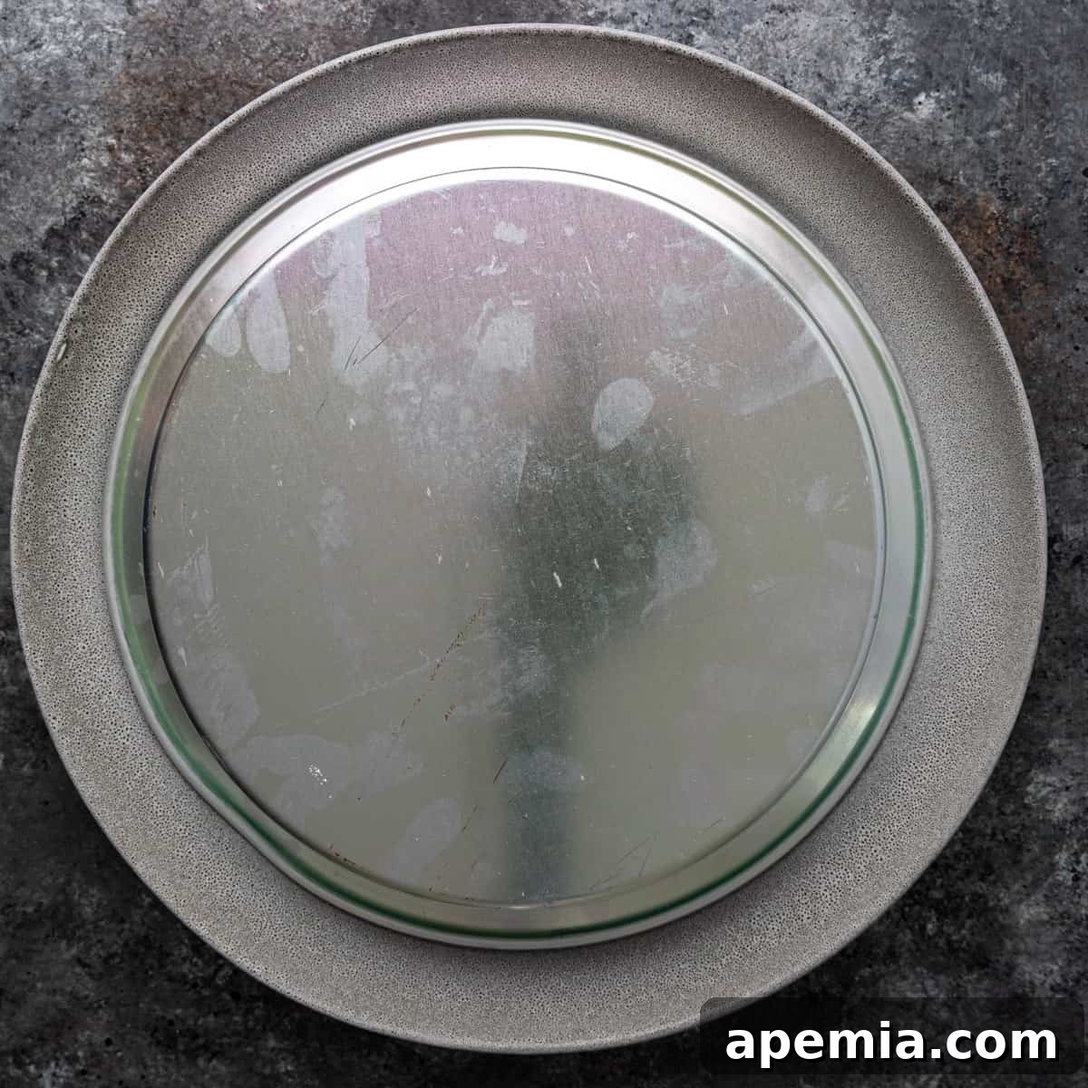 Overhead view of the baked knafeh in its pan, inverted onto a serving platter, preparing to be revealed.