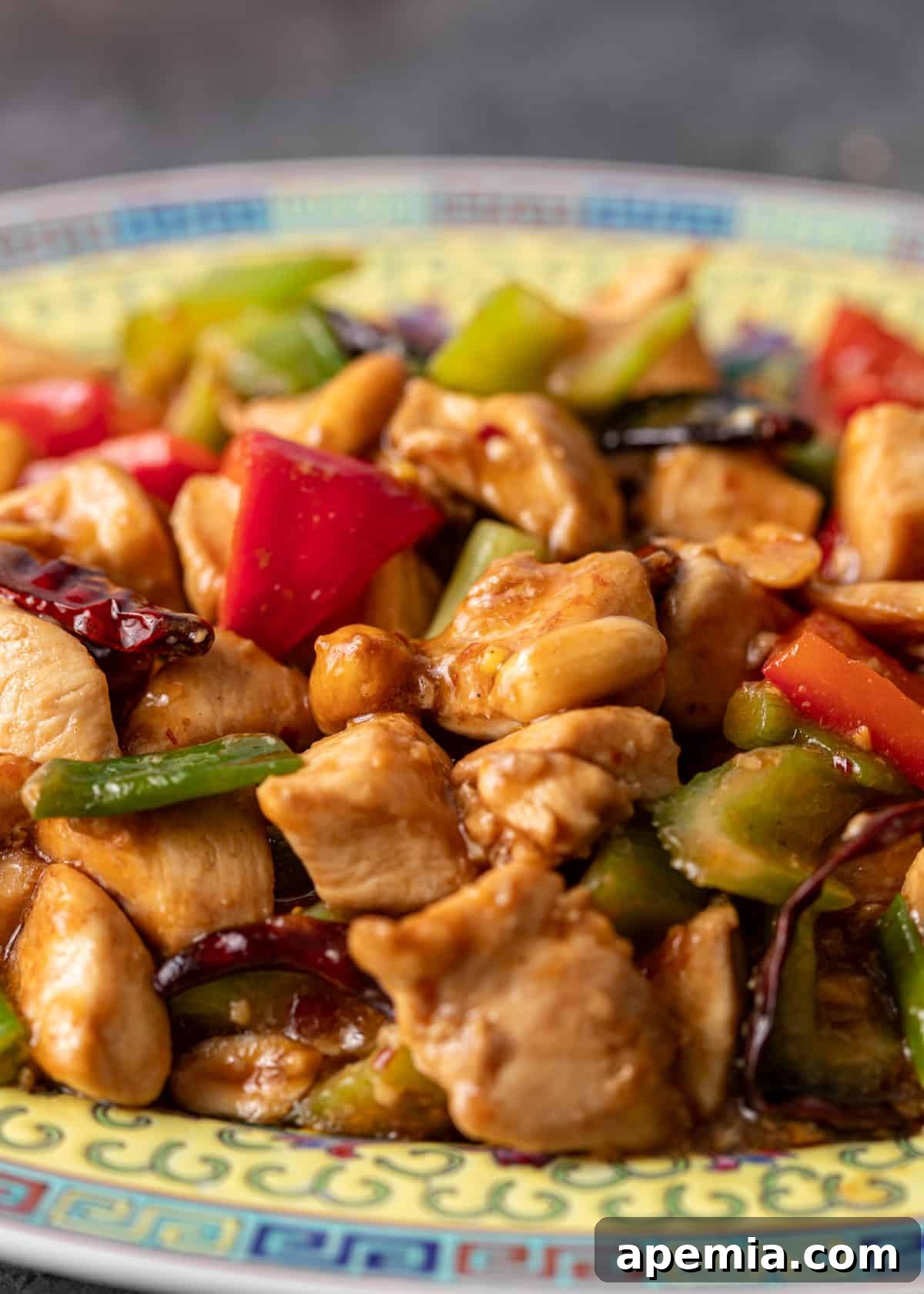 closeup: kung pao chicken recipe on a colorful ceramic plate with chicken and vegetables shown