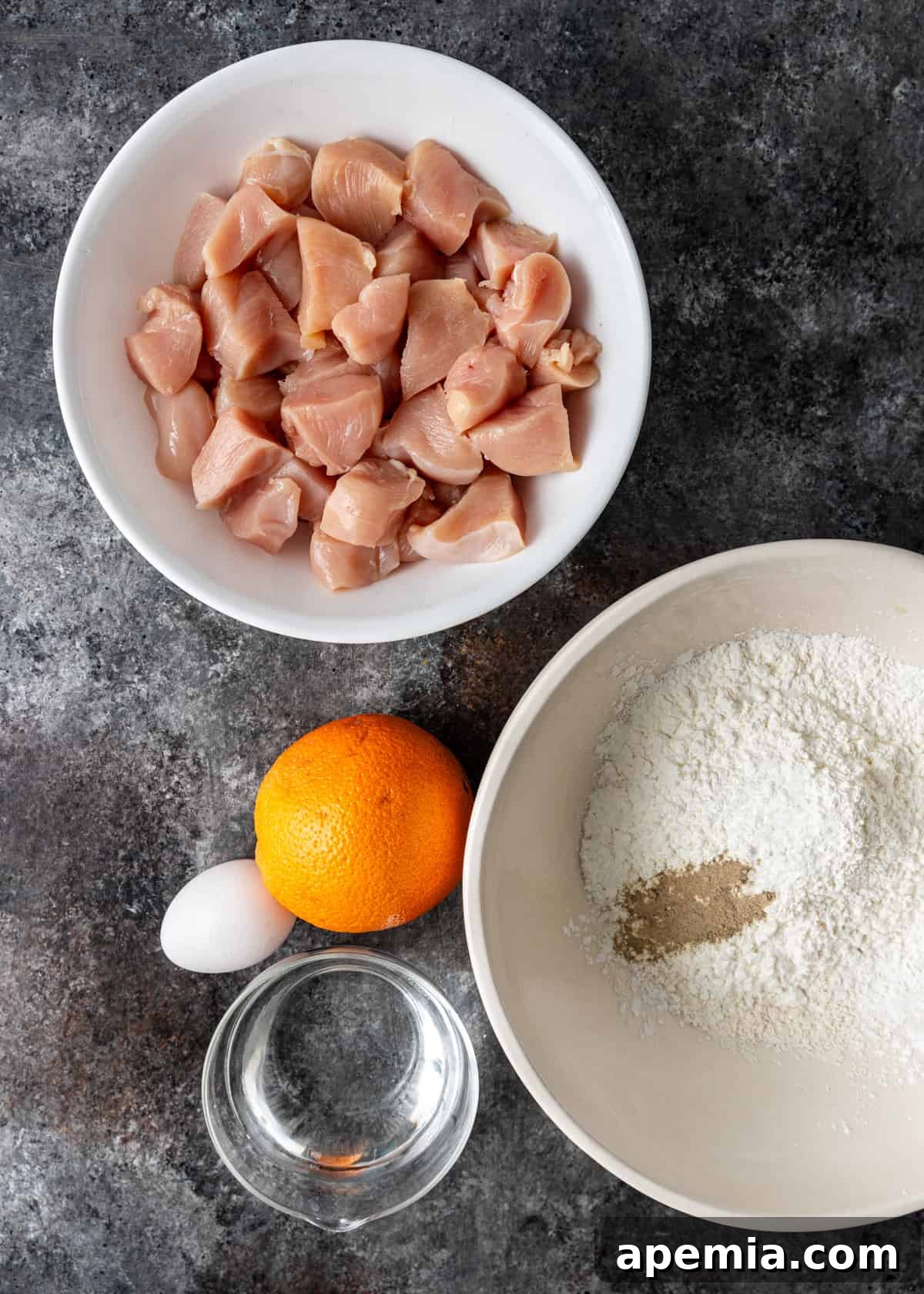 Overhead view of all fresh ingredients laid out on a clean counter, meticulously prepared for making orange chicken.