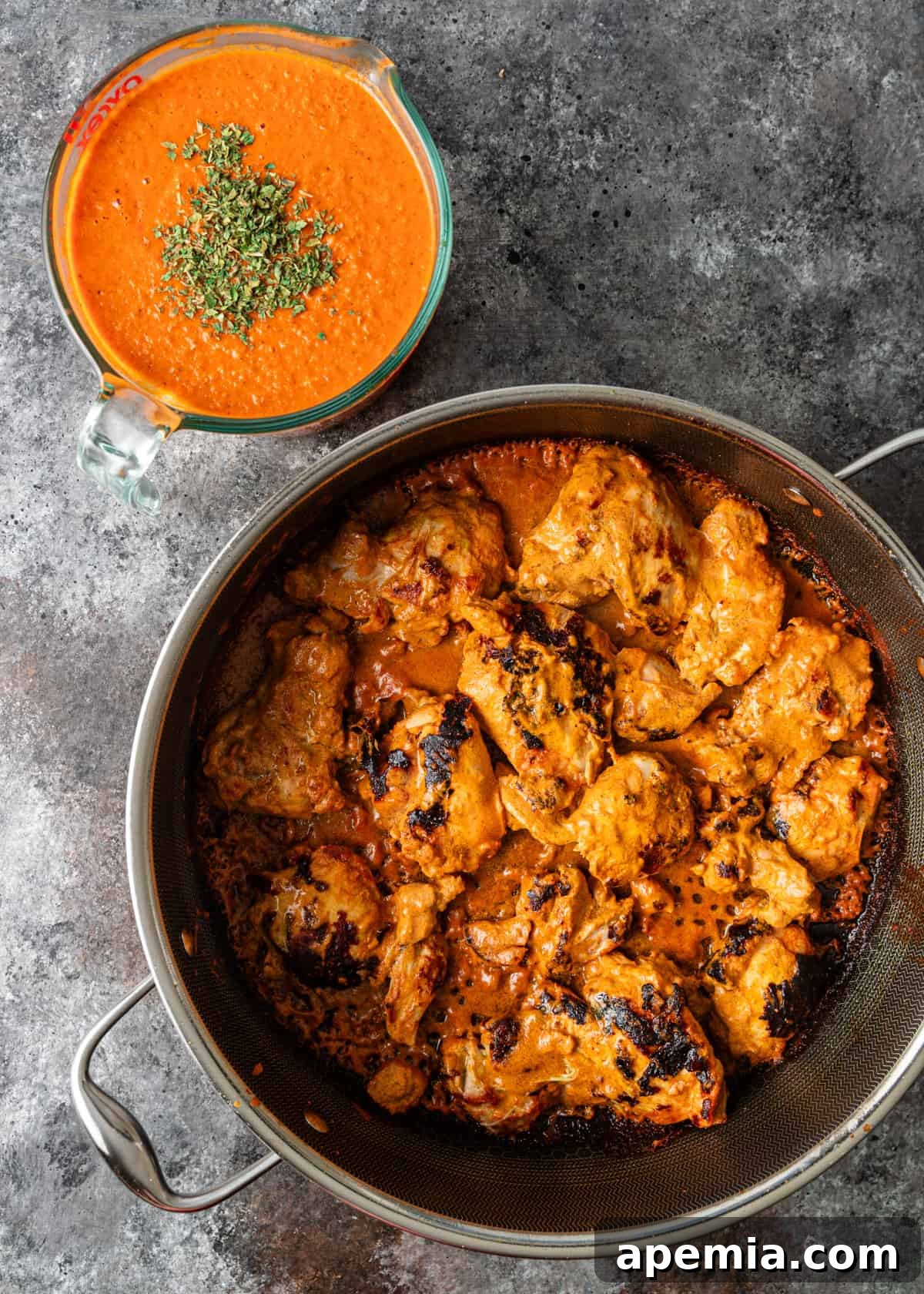 overhead process shot: cooking marinated chicken tikka in a pot