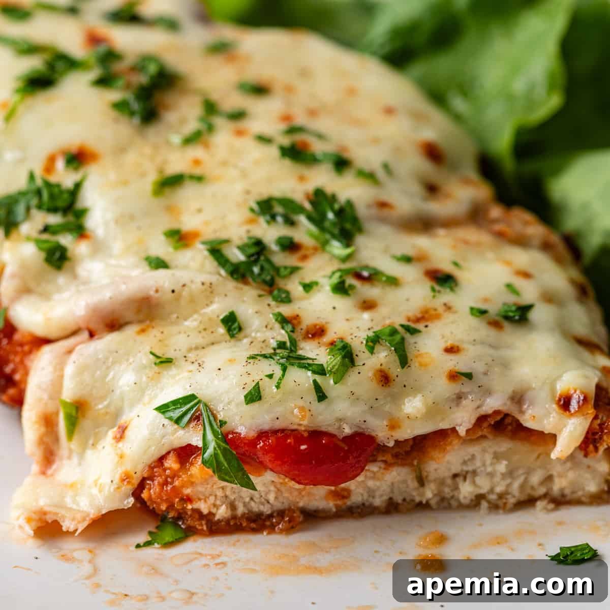 closeup: sliced Classic Chicken Parmigiana on plate