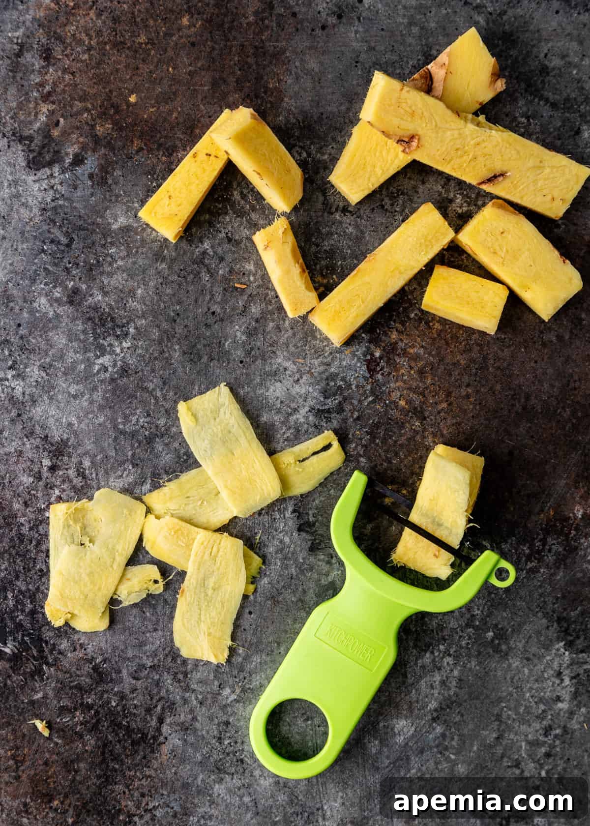 A hand peeling fresh ginger root with a vegetable peeler, demonstrating the first step in preparation.