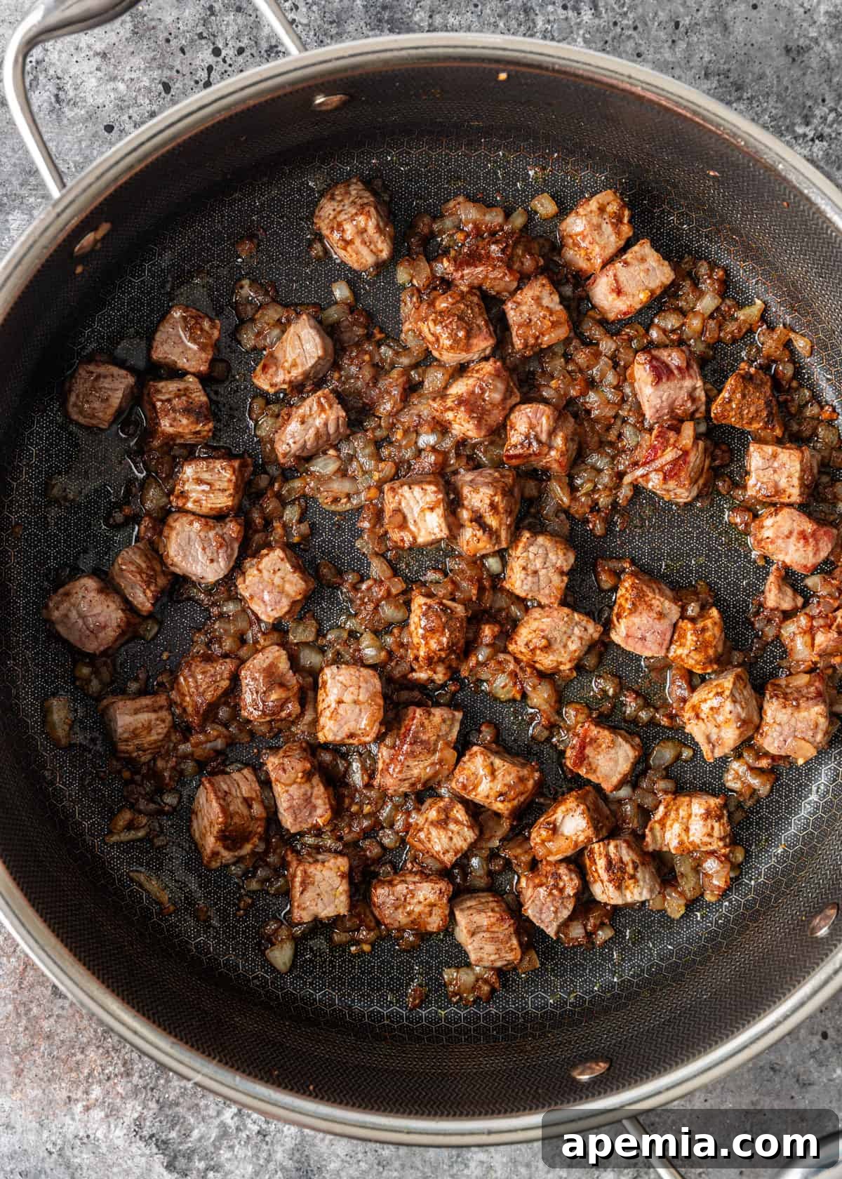 Spiced Beef and Sweet Potato Tagine 6 Sautéing beef cubes alongside softened onions and ginger in a frying pan, browning the meat on all sides.