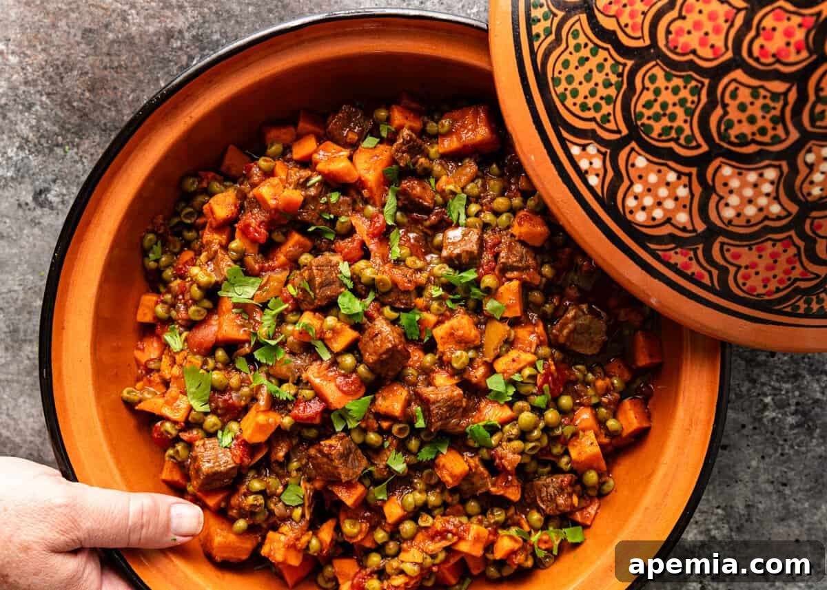 Spiced Beef and Sweet Potato Tagine 9 Overhead view of a prepared ceramic dish of beef tagine, with the lid placed next to it, showcasing the rich, slow-cooked contents.