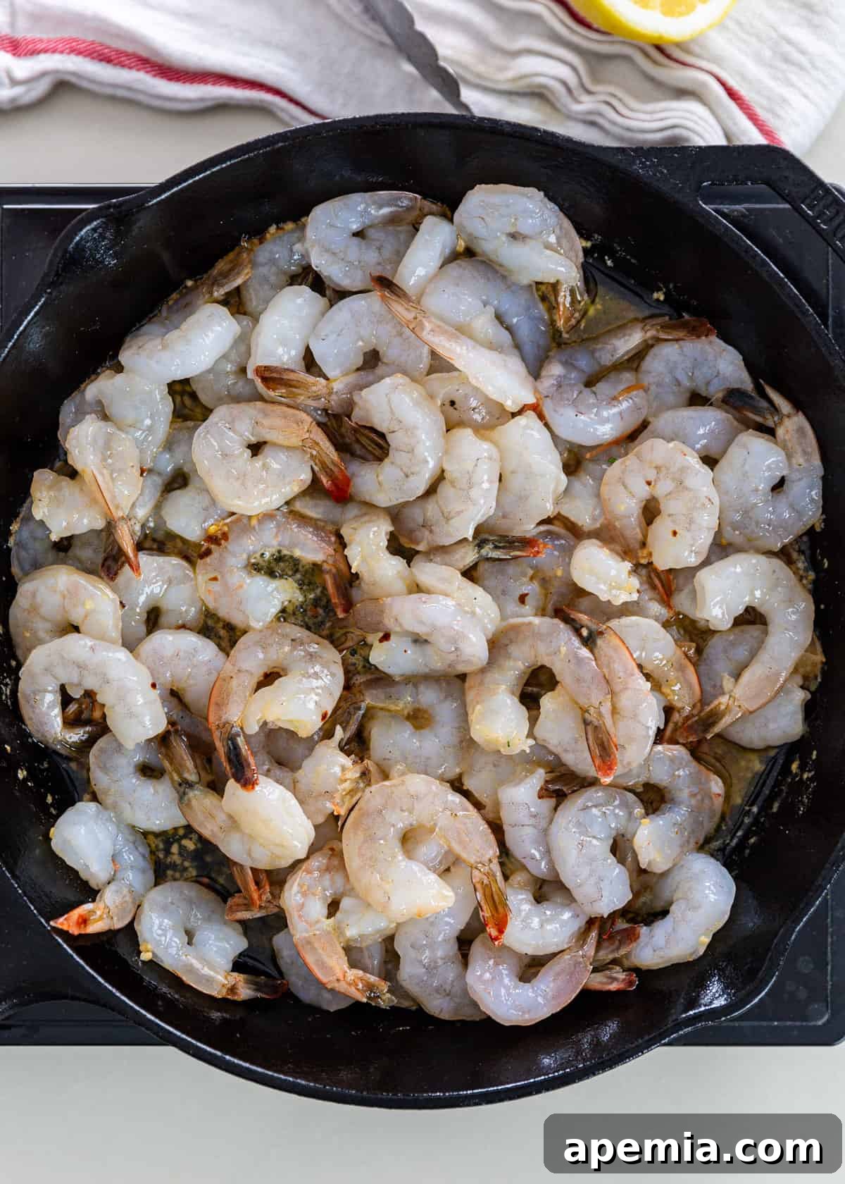 overhead: shrimp added to sautéed garlic in a pan