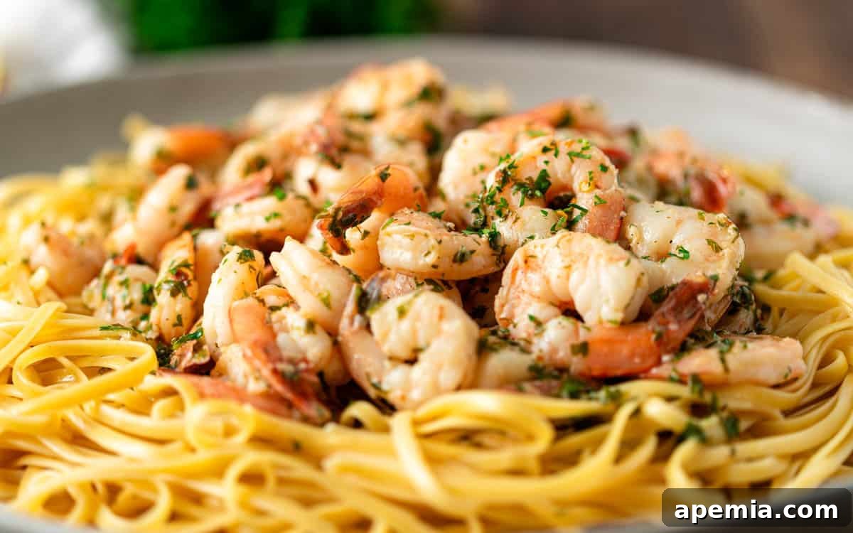 side view: shrimp scampi over linguine on a plate