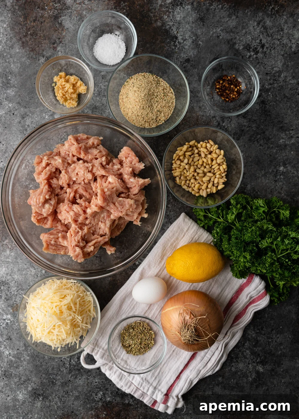Overhead view of all the fresh ingredients laid out on a counter, ready to be combined for the chicken meatball recipe.