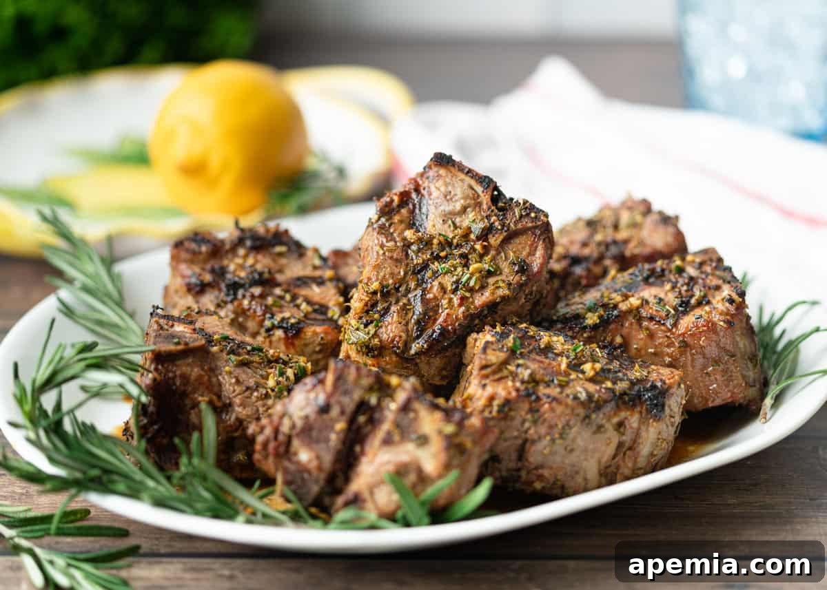 a serving dish with greek lamb chops with rosemary and lemon on the side, ready for dining