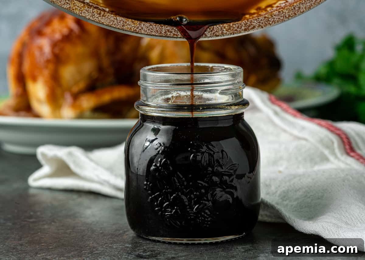 Side view: pouring freshly made teriyaki sauce into a clear glass jar, showcasing its smooth texture.