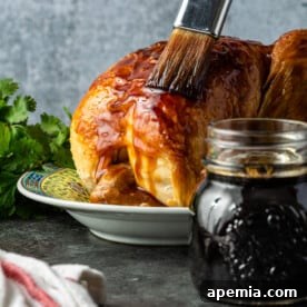 Basting teriyaki sauce on roast chicken for a delicious glaze.