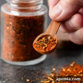 A small bowl of homemade Shichimi Togarashi with a wooden spoon, ready to be used as a flavorful Japanese condiment.