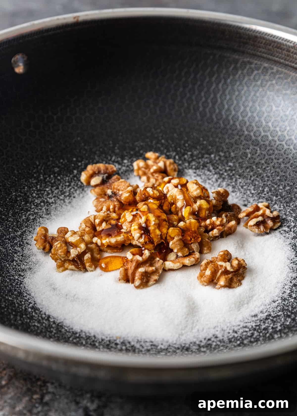 Golden Honey Walnut Shrimp 4 Process shot: Walnuts, sugar, and honey heating in a skillet, beginning to caramelize.