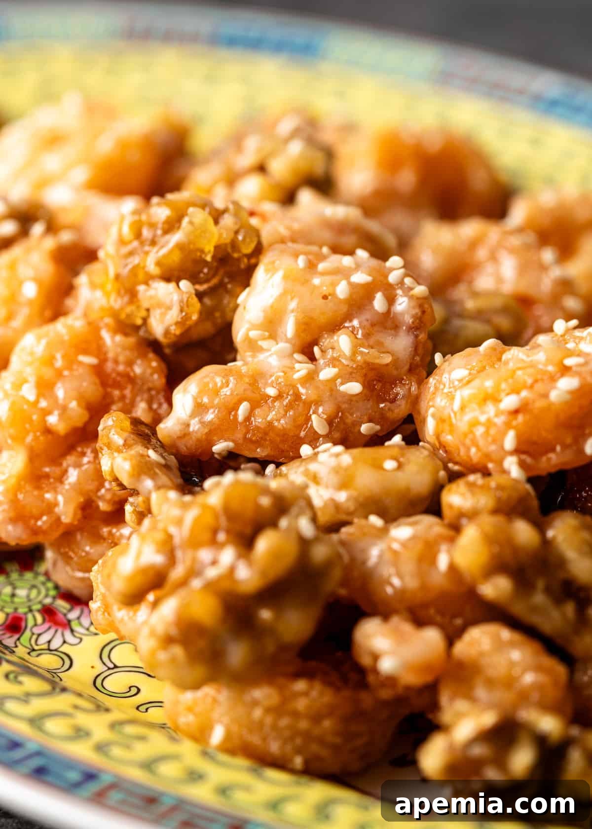Golden Honey Walnut Shrimp 10 Extreme close-up of a single honey walnut shrimp, showcasing its crispy coating, creamy sauce, and sprinkled sesame seeds.
