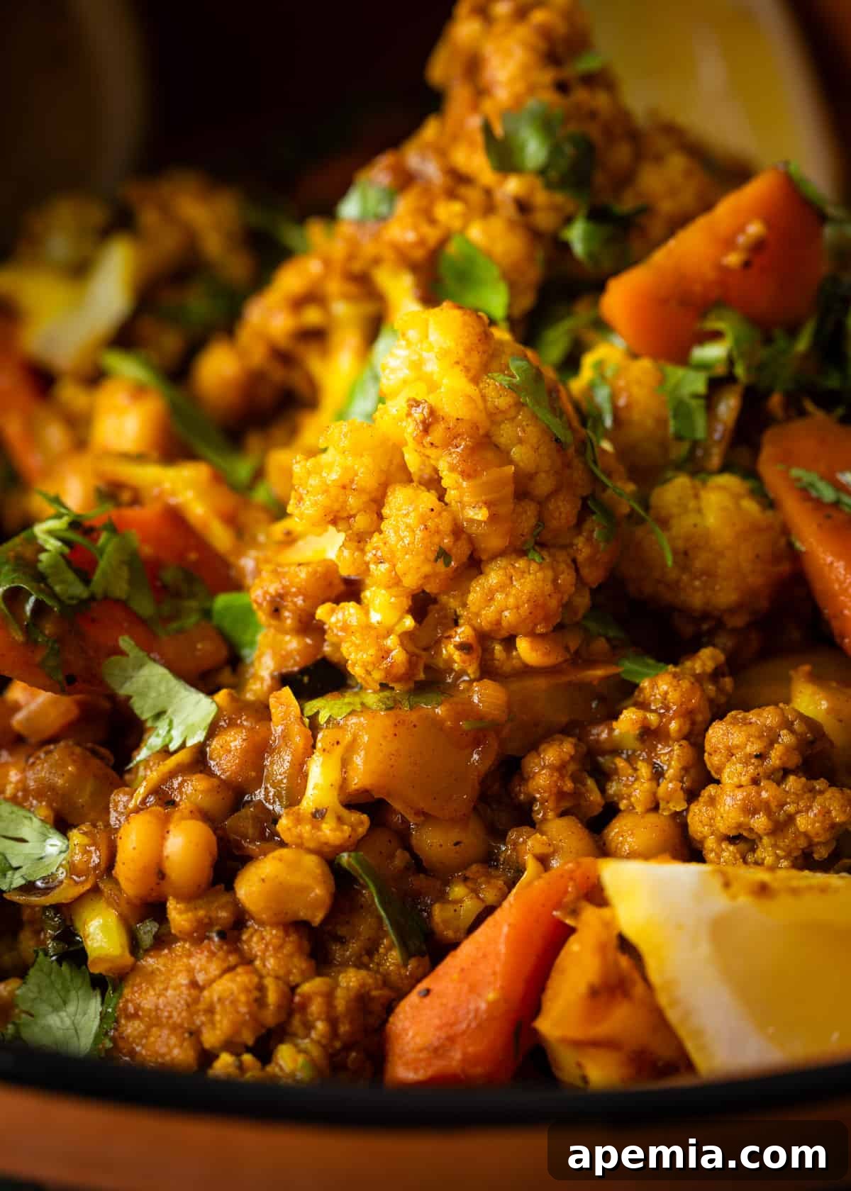 Moroccan Cauliflower and Carrot Tagine 8 Extreme close-up of the vegetable tagine, showcasing the tender cauliflower, carrots, and chickpeas with rich sauce.