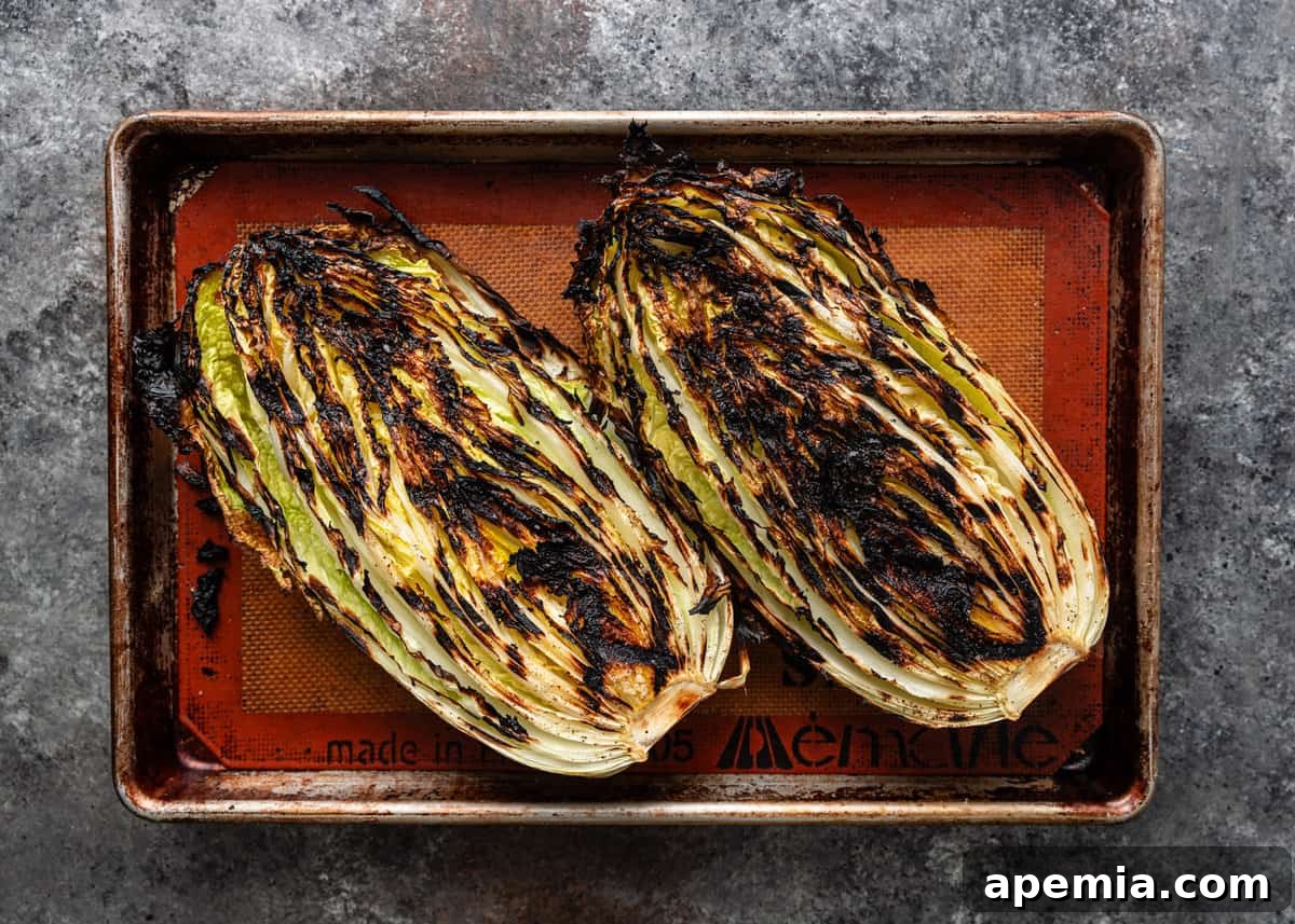 Sweet Chili Glazed Grilled Cabbage 5 Overhead shot of charred napa cabbage halves resting on a baking sheet after being removed from the grill, showing off their beautiful grill marks.