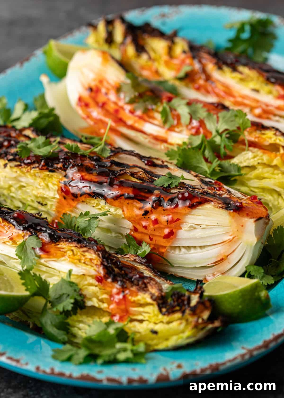 Sweet Chili Glazed Grilled Cabbage 8 Side view of a perfectly plated grilled cabbage recipe with sweet chili sauce, fresh cilantro, and lime wedges, ready to be enjoyed.