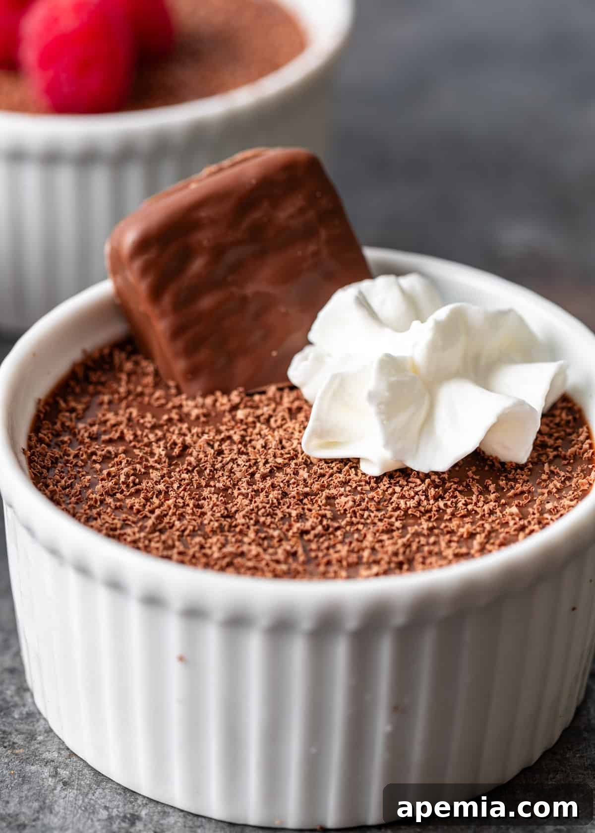 Decadent Chocolate Pots de Crème 3 closeup: individual chocolate pots de creme recipe served in small white ramekins with whipped cream on top and fresh berries, showcasing elegant presentation