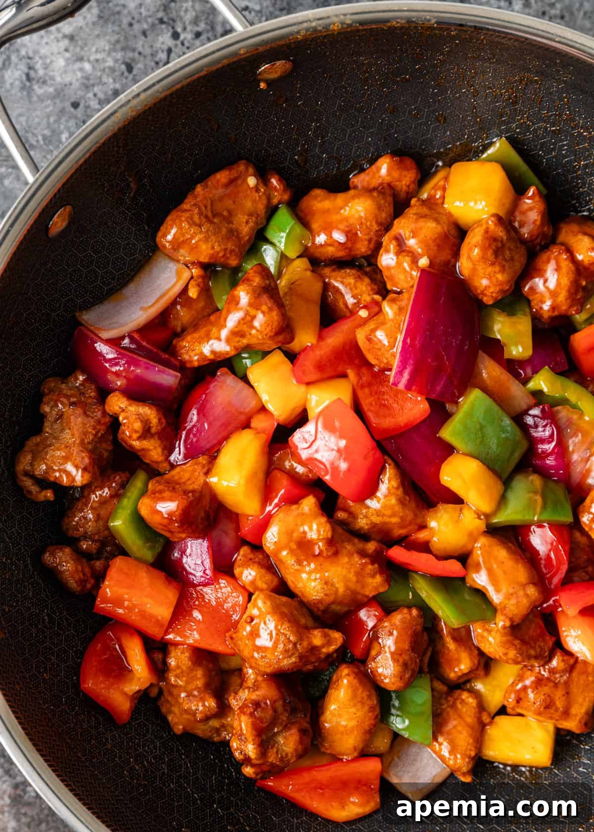overhead: the full sweet and sour pork recipe being stir-fried in a large wok