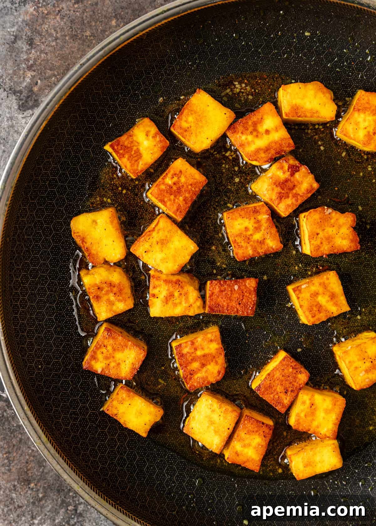Palak Paneer Creamy Spinach and Indian Cheese Curry 6 An overhead view of paneer cheese cubes sizzling in a hot pan, gradually turning golden brown and developing a desirable crispy exterior, a crucial step for texture.