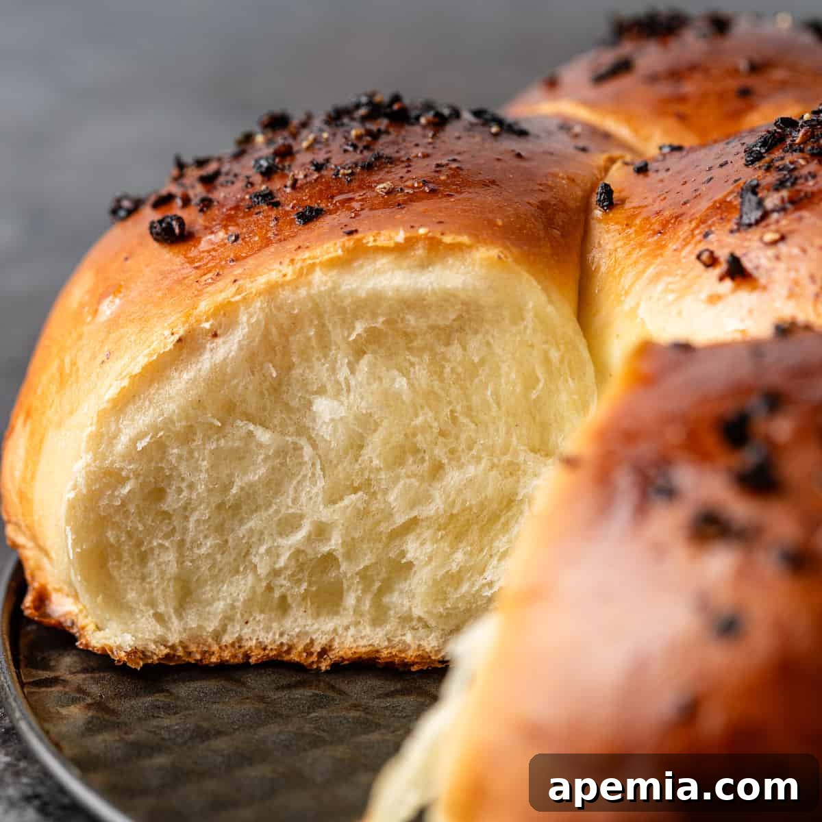 Closeup of Japanese milk bread with a slice removed, revealing its incredibly soft, fluffy interior.