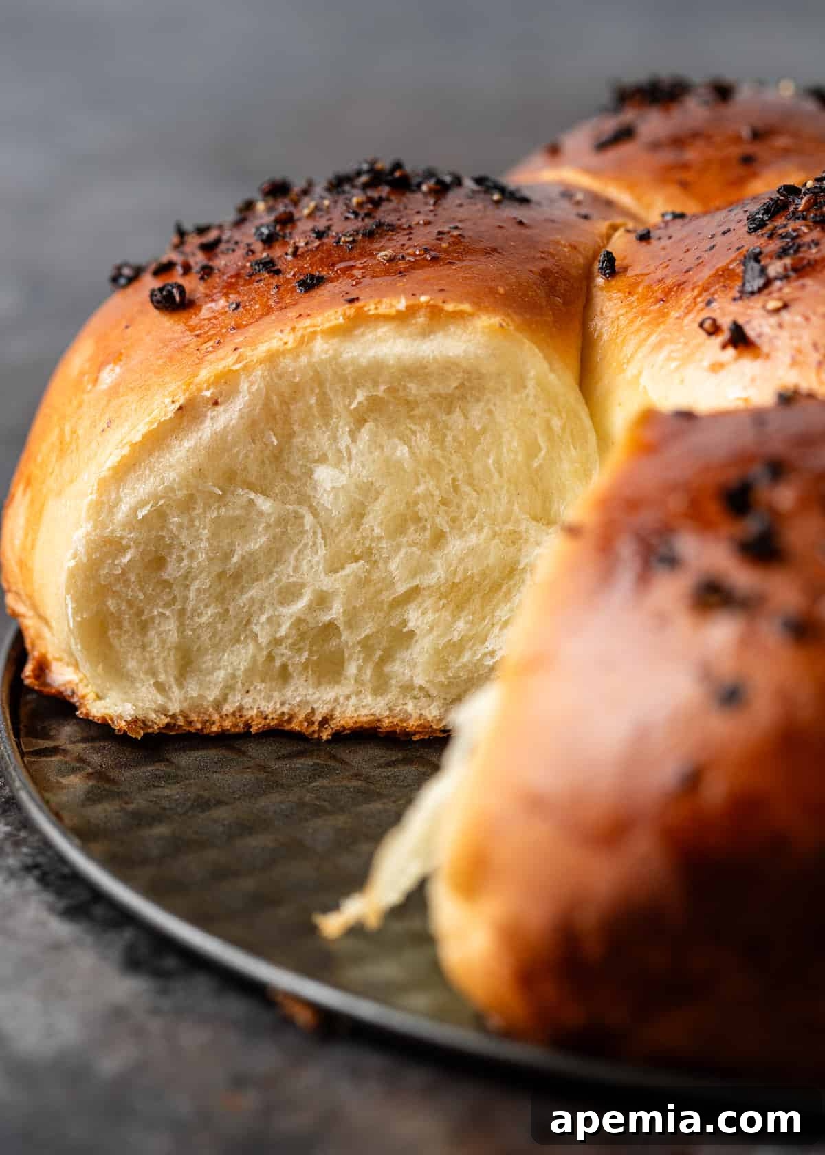 Closeup of a Japanese milk bread roll with its incredibly fluffy and soft interior exposed.