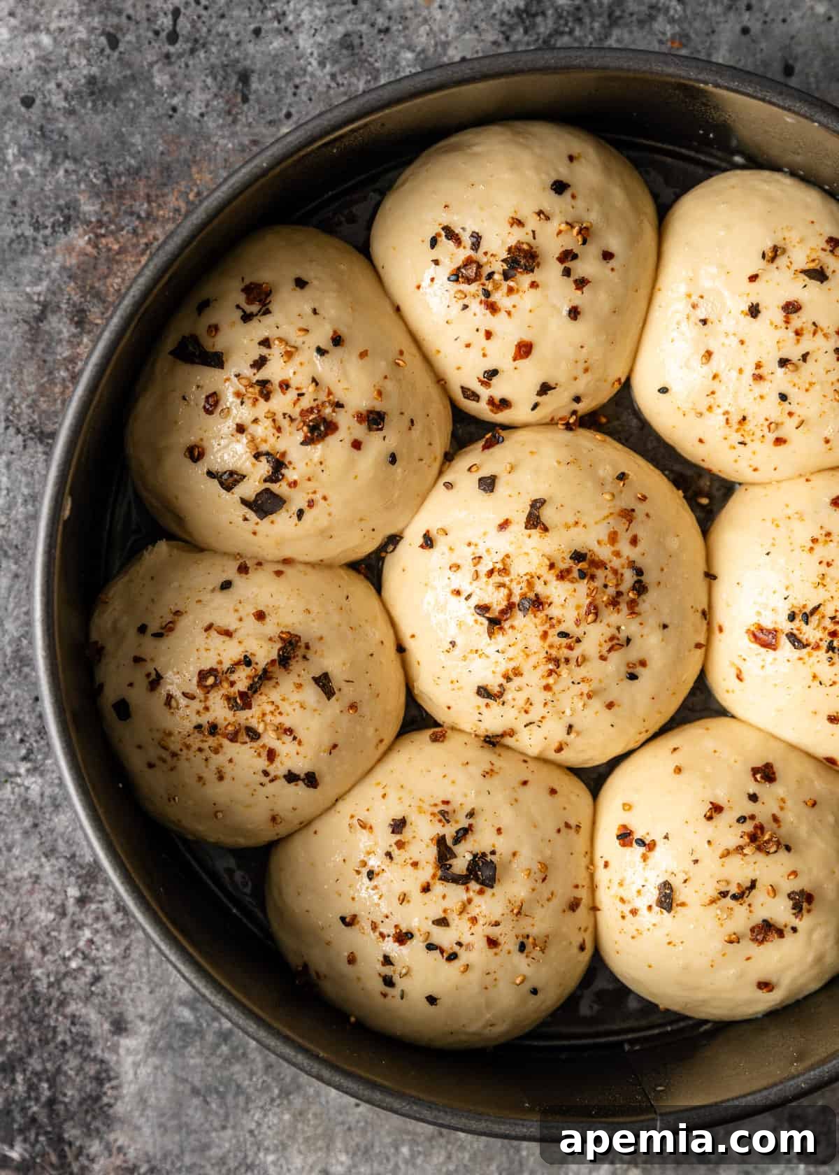 Overhead process shot: Dough balls topped with optional furikake seasoning, ready for the oven.