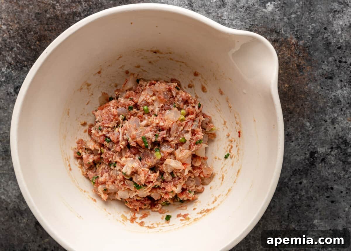 overhead process shot: wonton soup recipe ingredients combined in a bowl